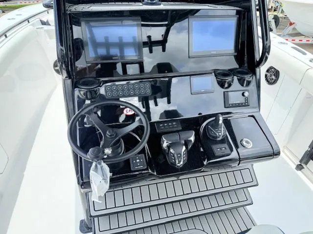 Slide: The Image of 2026 Tidewater 302 CC Adventure boat dashboard with dual screens and steering wheel. - 6