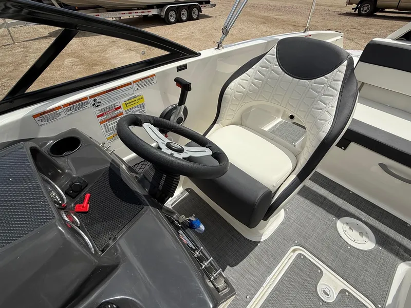 Slide: The Image of 2021 Bayliner VR5 boat cockpit with steering wheel and cushioned seat. - 11