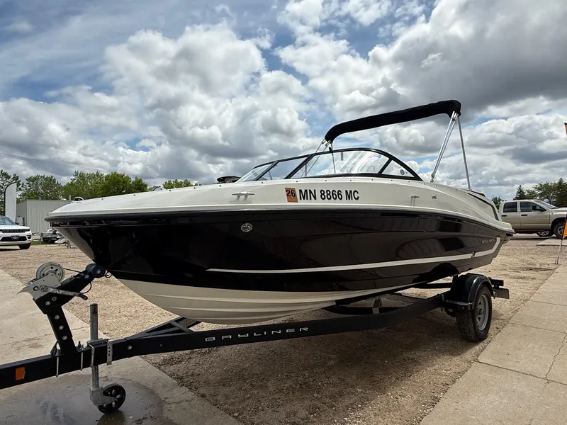 Slide: The Image of 2021 Bayliner VR5 boat on trailer under cloudy sky. - 2