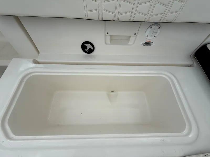 Slide: The Image of 2021 Bayliner VR5 boat storage compartment with white interior and cushioned seating. - 21