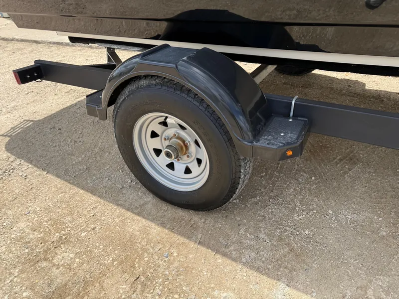 Slide: The Image of Trailer wheel of a 2021 Bayliner VR5 boat on a dirt surface. - 28