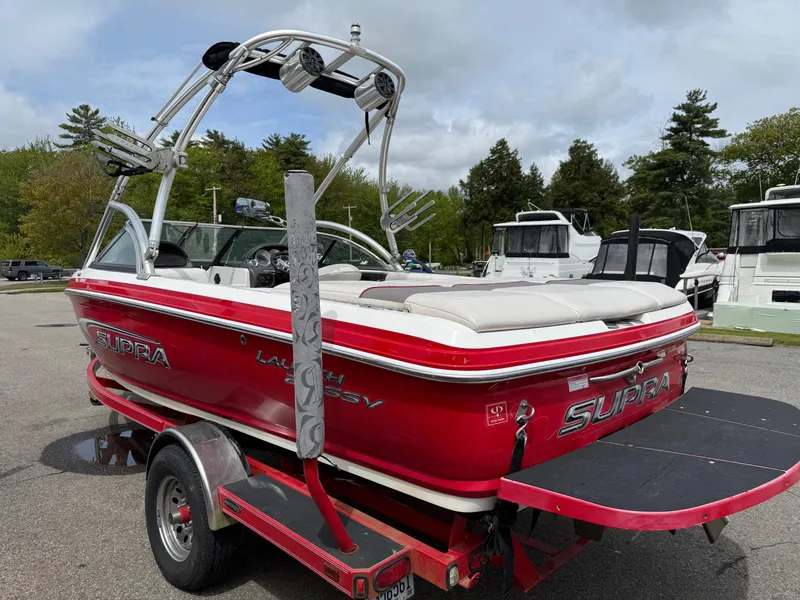 Slide: The Image of 2007 Supra Launch 20 SSV boat in red, parked on a trailer, with wakeboard tower. - 12