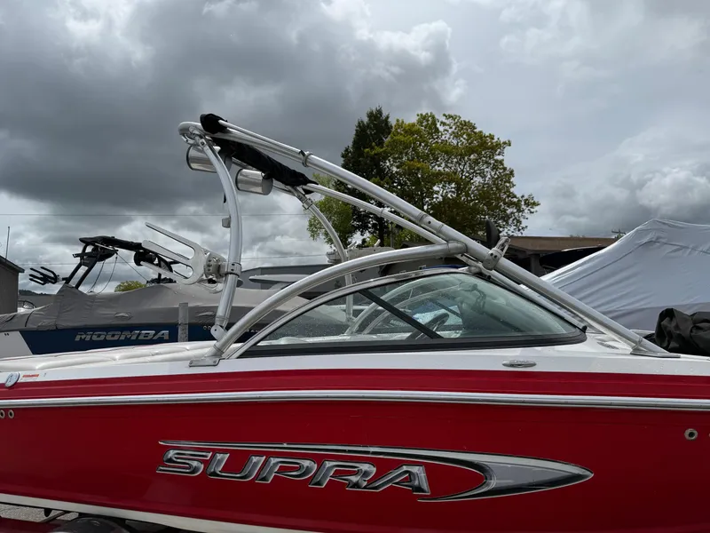 Slide: The Image of 2007 Supra Launch 20 SSV boat with red exterior under cloudy sky. - 2