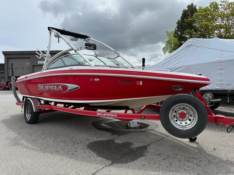 Slide: The Image of 2007 Supra Launch 20 SSV boat in red on trailer, parked outdoors. - 3