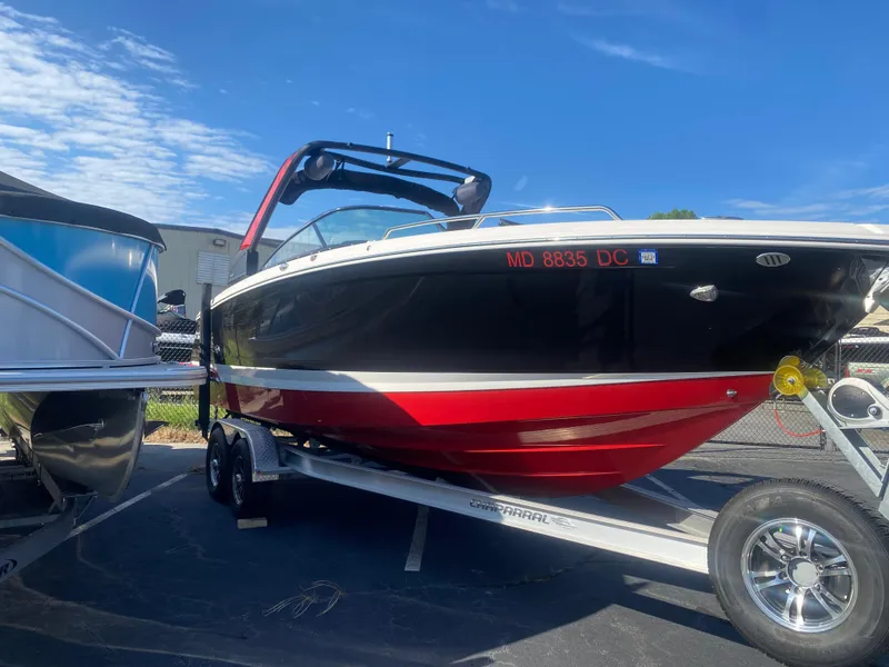 Slide: The Image of 2021 Chaparral 287 SSX boat on trailer, black and red exterior, parked outdoors. - 1