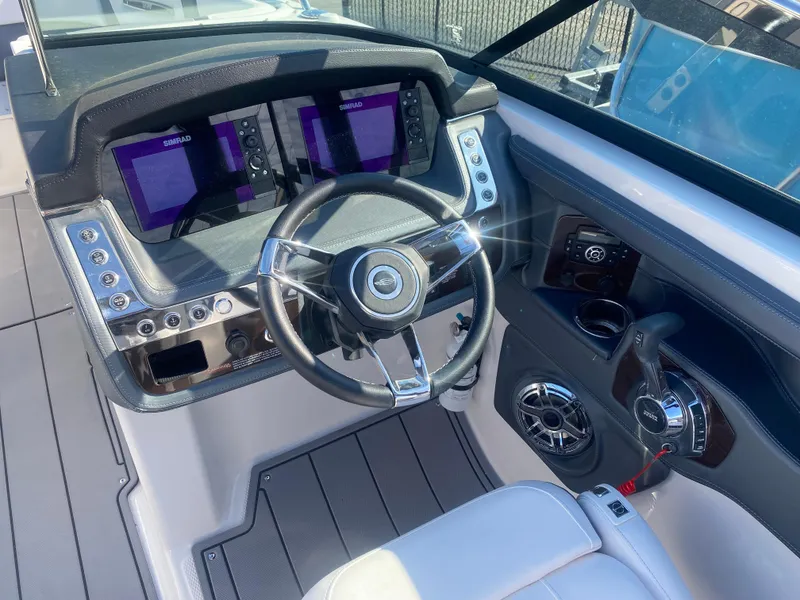 Slide: The Image of 2021 Chaparral 287 SSX boat dashboard with dual displays and steering wheel. - 3