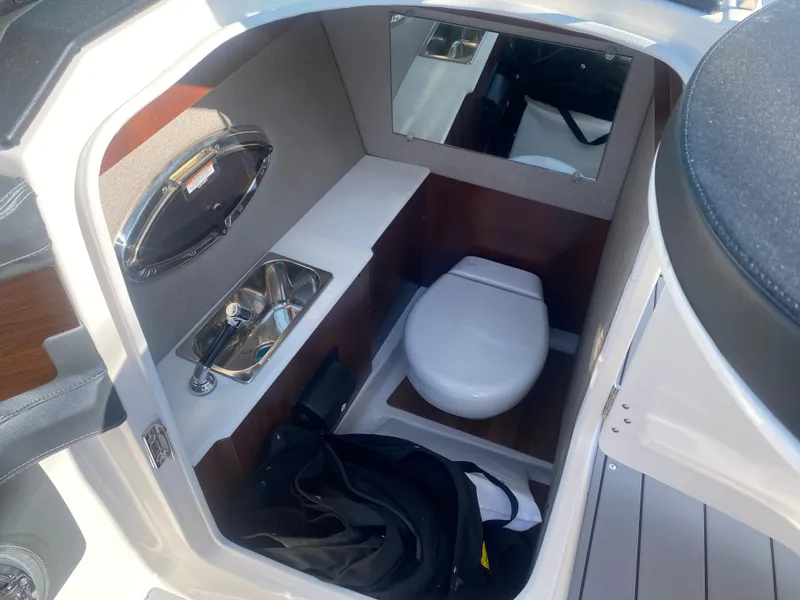 Slide: The Image of 2021 Chaparral 287 SSX boat interior with compact bathroom, sink, and mirror. - 6
