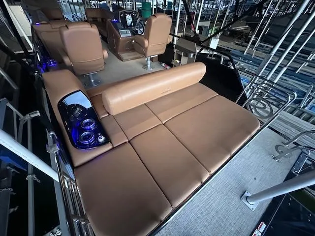 Slide: The Image of 2022 Regency 250 LE3 Sport boat interior with tan seating and blue LED cup holders. - 12