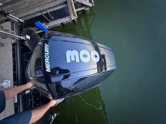 Slide: The Image of Mercury outboard motor on 2022 Regency 250 LE3 Sport boat, docked by water. - 13