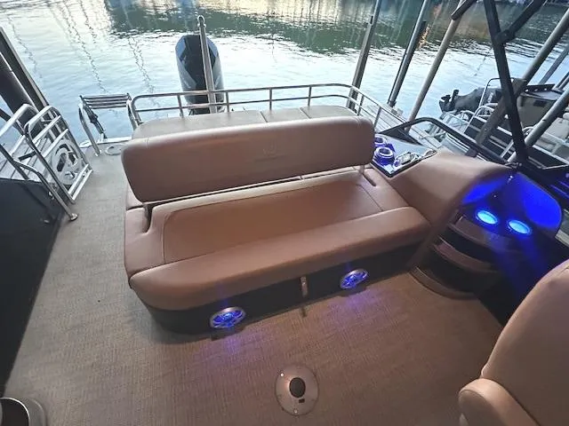 Slide: The Image of 2022 Regency 250 LE3 Sport boat interior with cushioned seating and blue LED lights. - 14