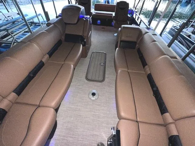 Slide: The Image of 2022 Regency 250 LE3 Sport boat interior with tan seating and carpeted floor. - 17