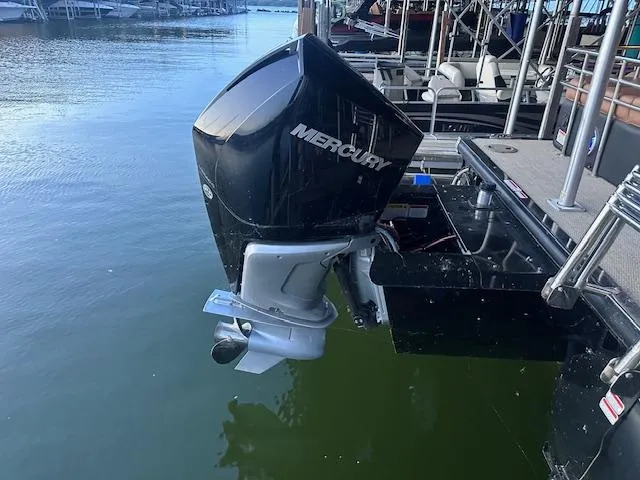 Slide: The Image of Outboard motor on a 2022 Regency 250 LE3 Sport boat docked by the water. - 29