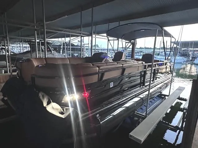 Slide: The Image of 2022 Regency 250 LE3 Sport pontoon boat docked in a marina. - 9