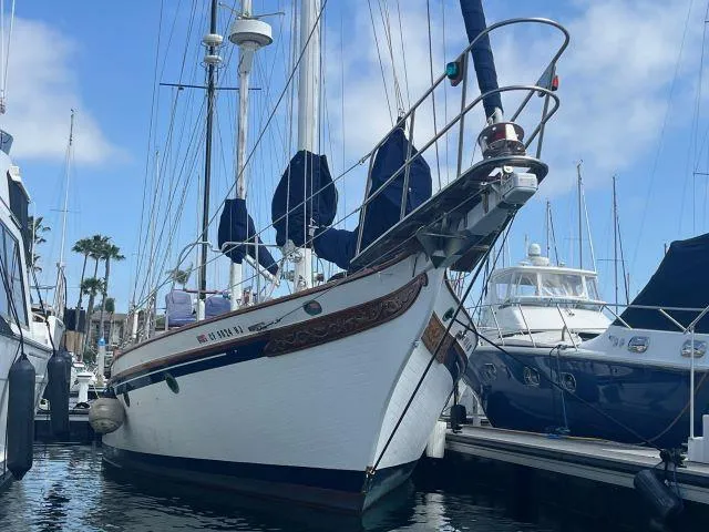 The Image of 1983 Bluewater Vagabond 47 sailboat docked in marina, clear sky background. - 0
