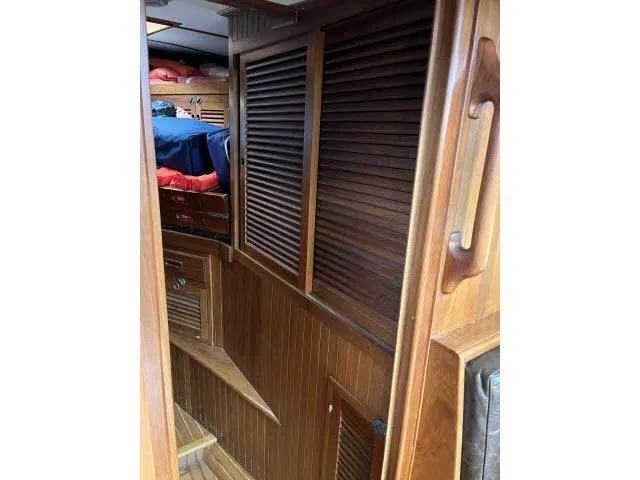 Slide: The Image of Interior of 1983 Bluewater Vagabond 47 sailboat with wooden paneling and cozy cabin. - 22