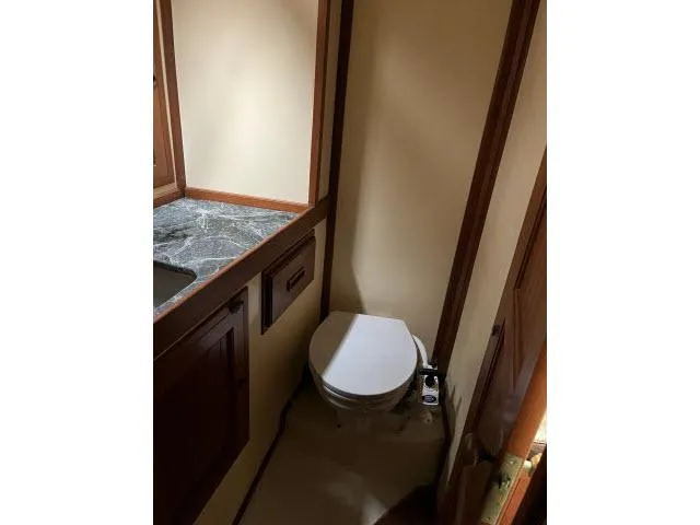 Slide: The Image of 1983 Bluewater Vagabond 47 yacht bathroom with toilet and marble countertop. - 30