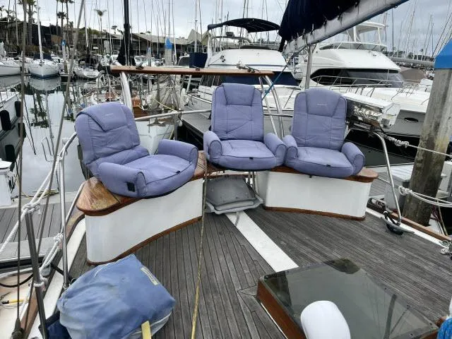 Slide: The Image of 1983 Bluewater Vagabond 47 yacht with cushioned seating on deck, docked at marina. - 35