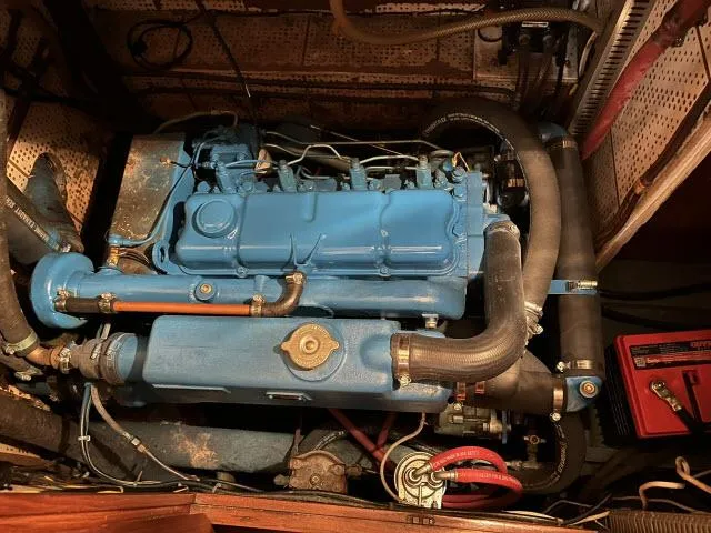 Slide: The Image of Engine of 1983 Bluewater Vagabond 47 sailboat, featuring blue components and hoses. - 48