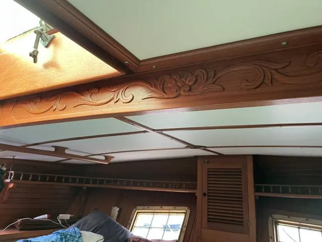Slide: The Image of Interior of 1983 Bluewater Vagabond 47 sailboat with carved wooden details and windows. - 54