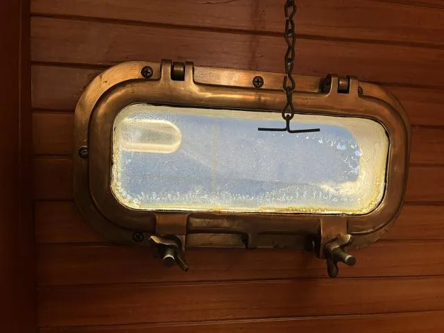 Slide: The Image of Porthole window on 1983 Bluewater Vagabond 47 sailboat, wooden interior. - 55