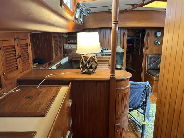 Slide: The Image of Interior of 1983 Bluewater Vagabond 47 yacht with wooden furnishings and a decorative lamp. - 8