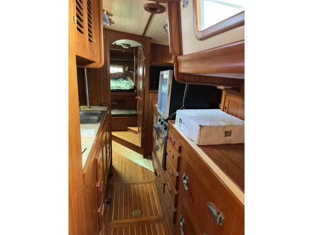 Slide: The Image of Interior of 1983 Bluewater Vagabond 47 sailboat with wooden cabinetry and cozy layout. - 9