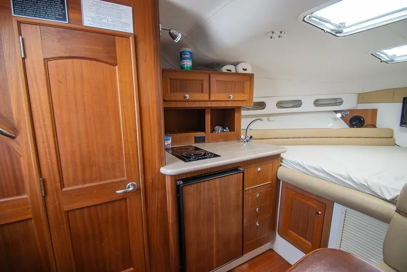 Slide: The Image of Interior of 2009 Pro-Line 35 Express boat with kitchenette and cozy sleeping area. - 11