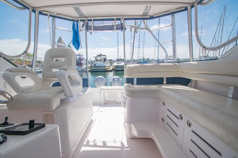 Slide: The Image of 2009 Pro-Line 35 Express boat interior with white seating and marina view. - 29