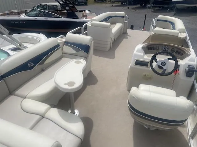 Slide: The Image of Pontoon boat interior with white seating, steering console, and table; Sedona LC 25, 2008 model. - 7