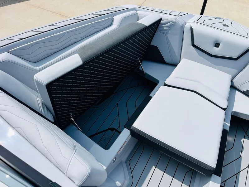 Slide: The Image of 2025 Nautique Super Air G23 boat interior with sleek seating and storage compartment. - 21