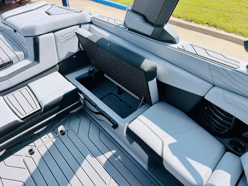 Slide: The Image of 2025 Nautique Super Air G23 interior with open storage compartment and sleek seating design. - 32