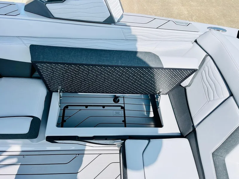 Slide: The Image of 2025 Nautique Super Air G23 boat storage compartment with open lid, showcasing sleek interior design. - 43