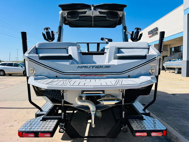 Slide: The Image of 2025 Nautique Super Air G23 boat, rear view, parked outdoors on a sunny day. - 5