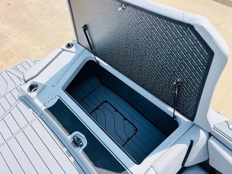 Slide: The Image of 2025 Nautique Super Air G23 storage compartment with open lid, showcasing spacious interior design. - 52