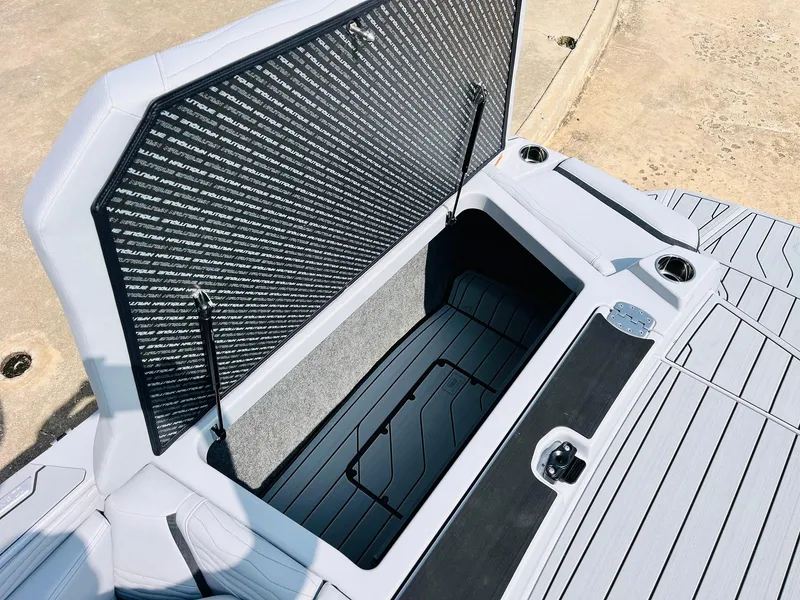 Slide: The Image of 2025 Nautique Super Air G23 open storage compartment with sleek design and durable materials. - 53