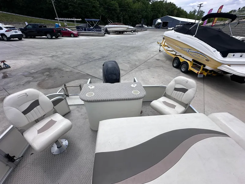 Slide: The Image of 2007 Bennington 2075GSi pontoon boat interior with seating and table, parked at a marina. - 7