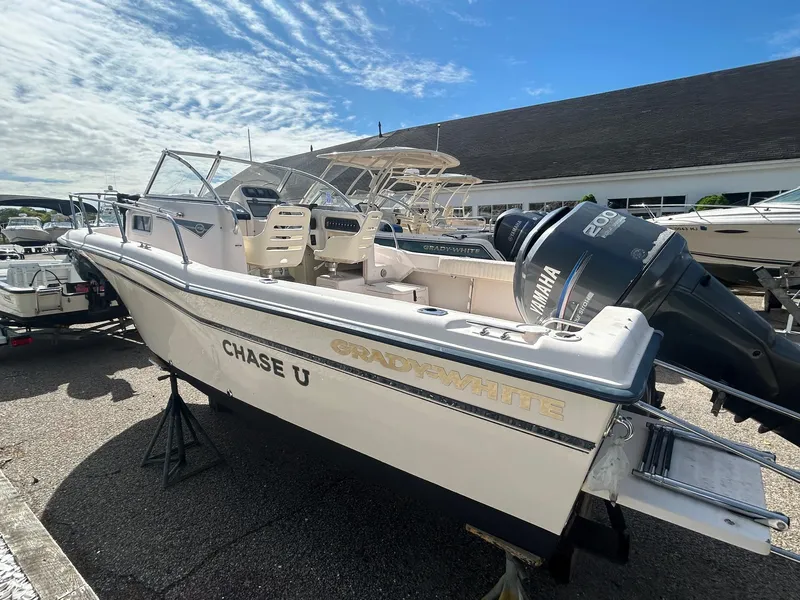Slide: The Image of 2006 Grady-White Adventure 208 boat with Yamaha engine, docked outdoors under a blue sky. - 0