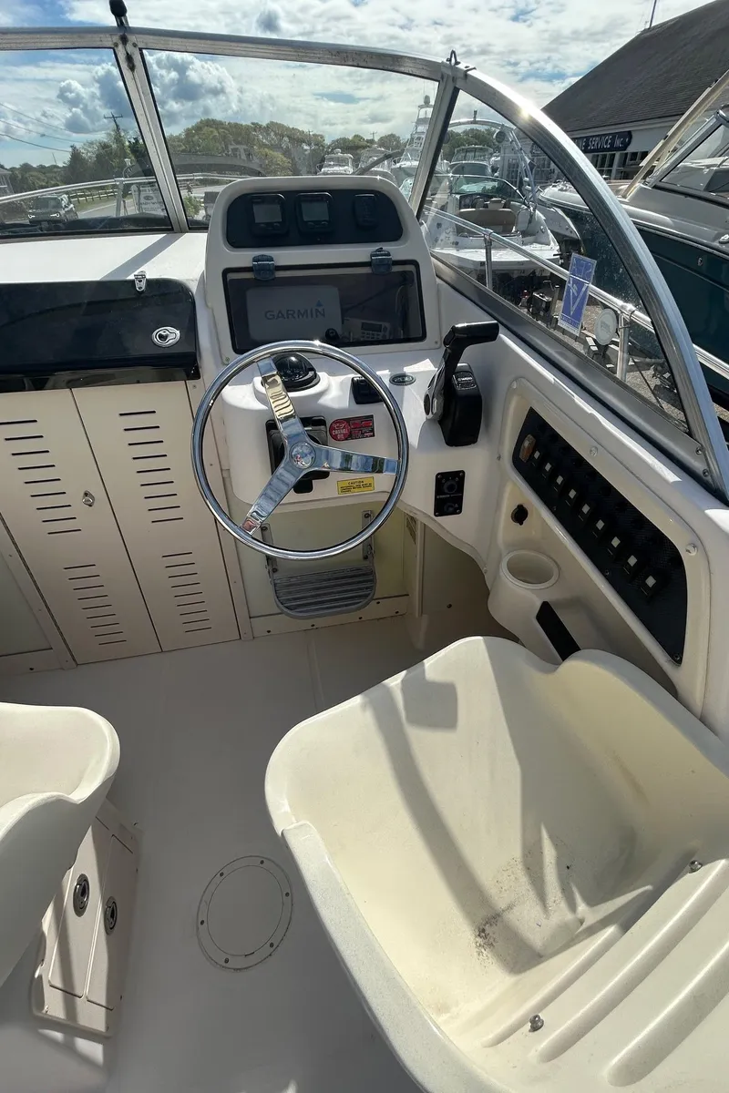 Slide: The Image of 2006 Grady-White Adventure 208 boat cockpit with steering wheel and control panel. - 10