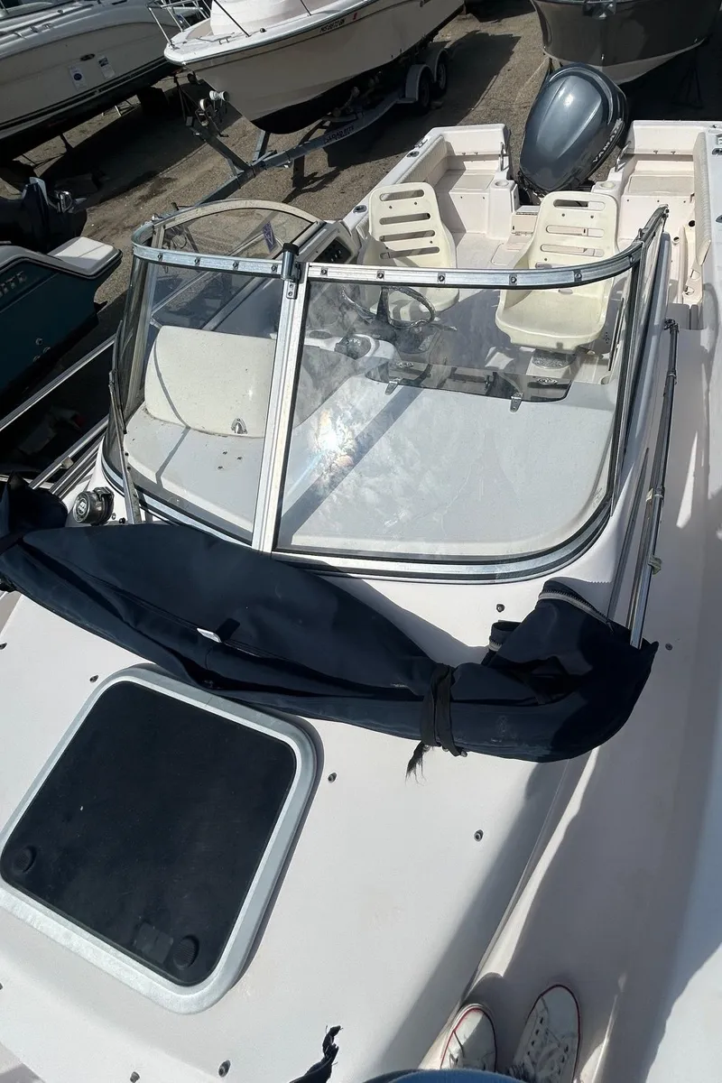 Slide: The Image of 2006 Grady-White Adventure 208 boat with windshield and seating, docked outdoors. - 8