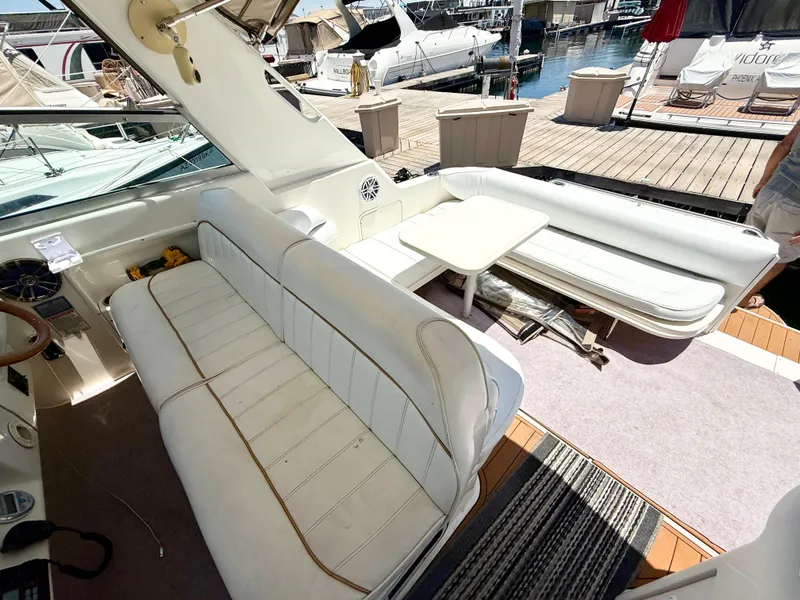 Slide: The Image of 1998 Sea Ray 330 Sundancer cabin interior with beige seating and dining table. - 10