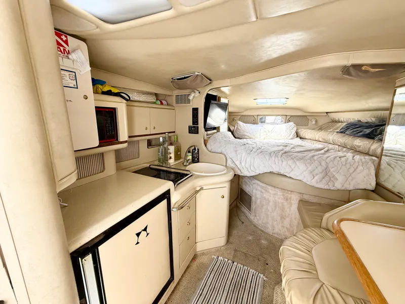 Slide: The Image of 1998 Sea Ray 330 Sundancer bathroom with sink, toilet, and storage shelves. - 13