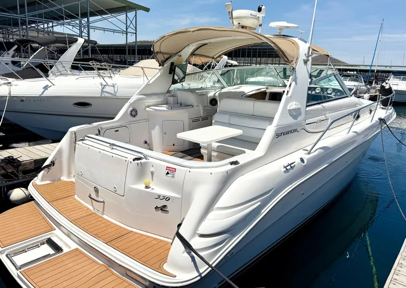Slide: The Image of 1998 Sea Ray Sundancer 330 docked, showcasing spacious deck and seating area. - 2