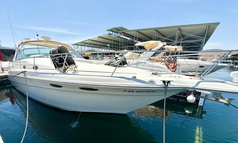 Slide: The Image of 1998 Sea Ray Sundancer 330 helm with white seating, steering wheel, and navigation equipment. - 3