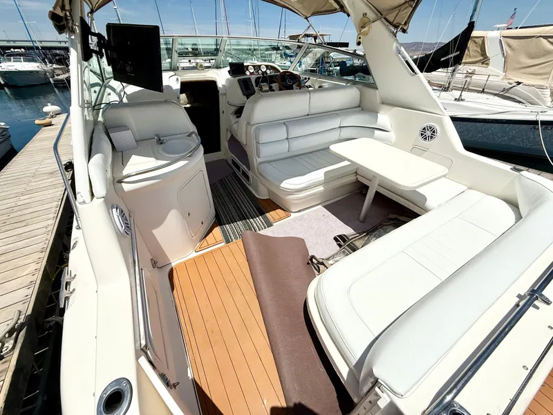 Slide: The Image of 1998 Sea Ray Sundancer 330 cockpit with marina view, featuring helm and seating area. - 5