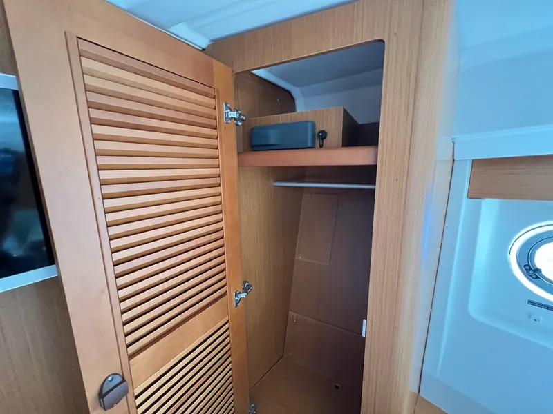 Slide: The Image of 2020 Beneteau Swift Trawler 35 interior closet with wooden louvered door and shelf. - 17