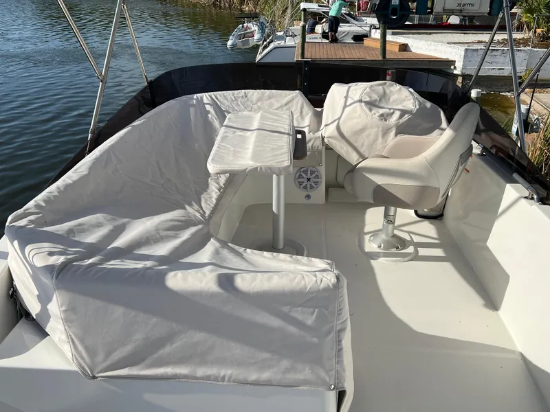 Slide: The Image of 2020 Beneteau Swift Trawler 35 deck with seating and helm, docked by the water. - 19