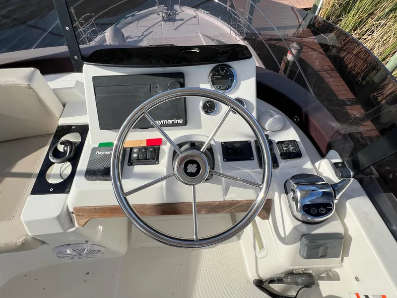 Slide: The Image of 2020 Beneteau Swift Trawler 35 helm with steering wheel and navigation controls. - 21