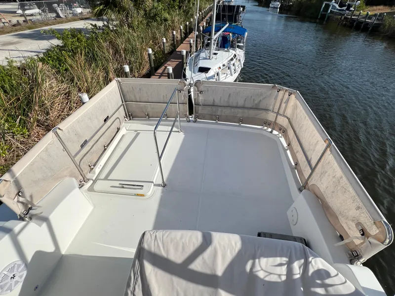 Slide: The Image of 2020 Beneteau Swift Trawler 35 flybridge with railing, docked by a canal. - 22