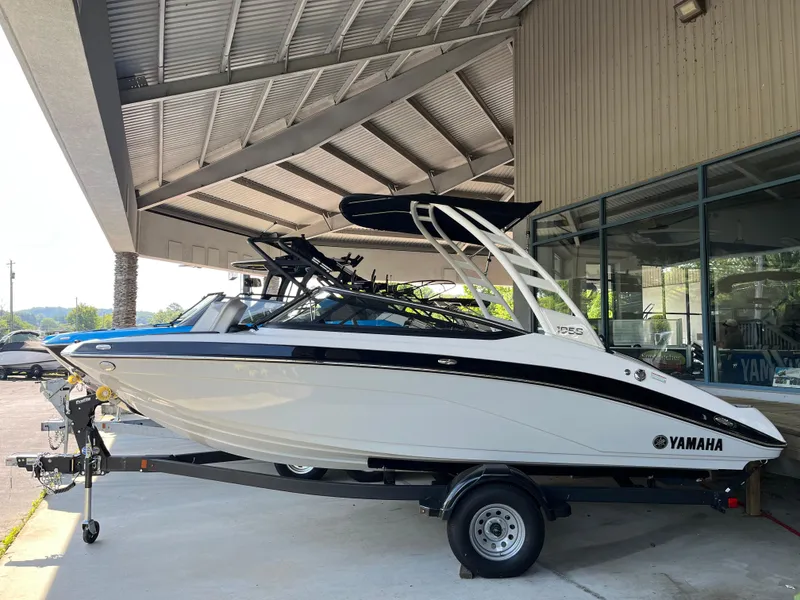 Slide: The Image of 2025 Yamaha Boats 195S on trailer under a covered area, side view. - 0