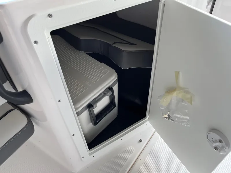 Slide: The Image of 2025 Yamaha AR190 boat storage compartment with cooler and keys. - 10